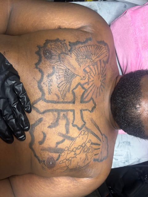 Large tattoo on persons arm featuring detailed African lion head design in black ink